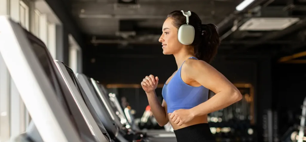 jovem-mulher-correndo-na-esteira-e-usando-headphone